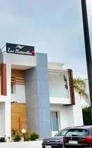 La villa Les Naturelles à Hay Riad : l’angle, l’enseigne sur le toit, l’écran de bois au balcon
